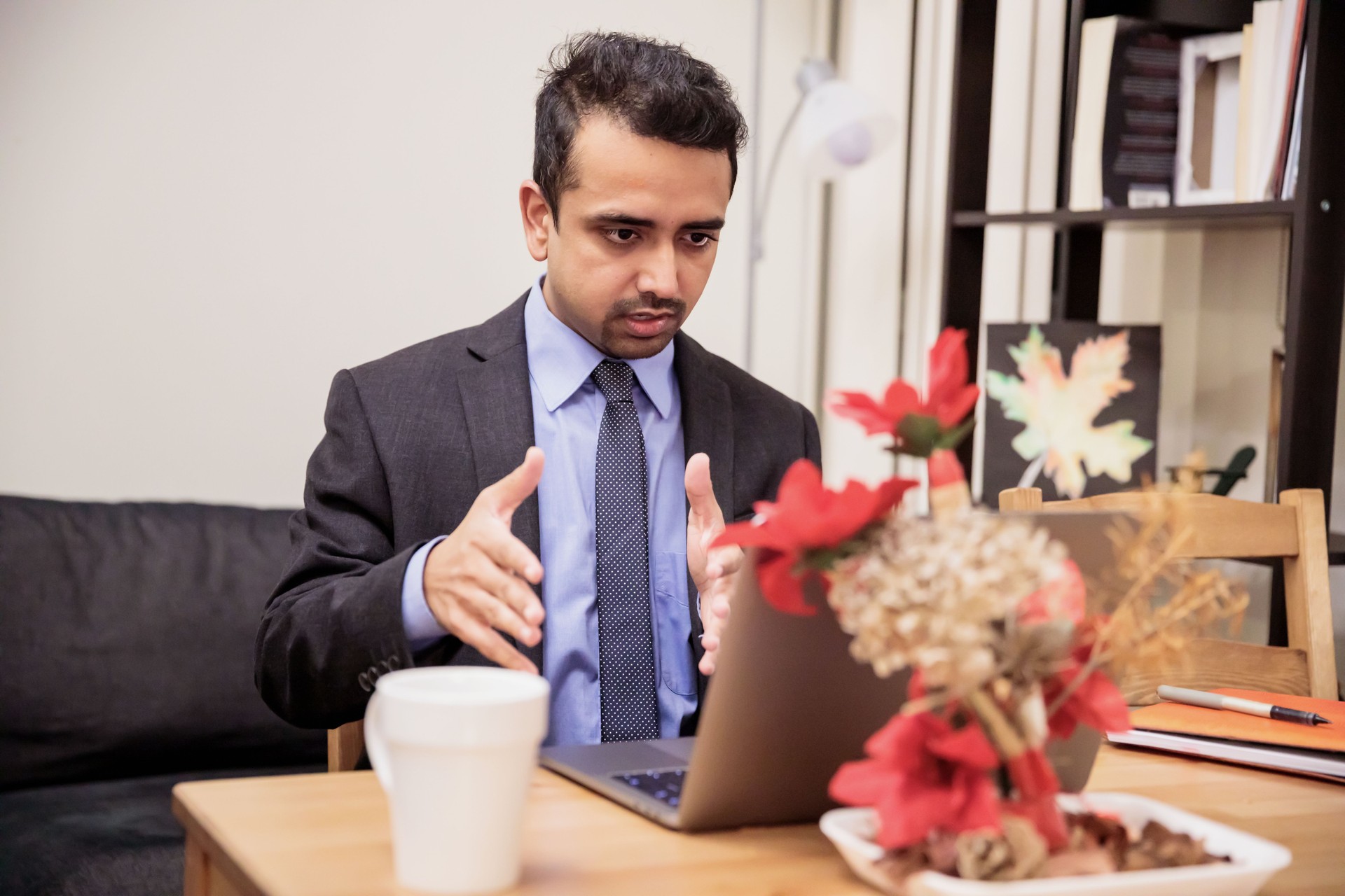 Young business executive presenting business proposition to his offshore client over video conference
