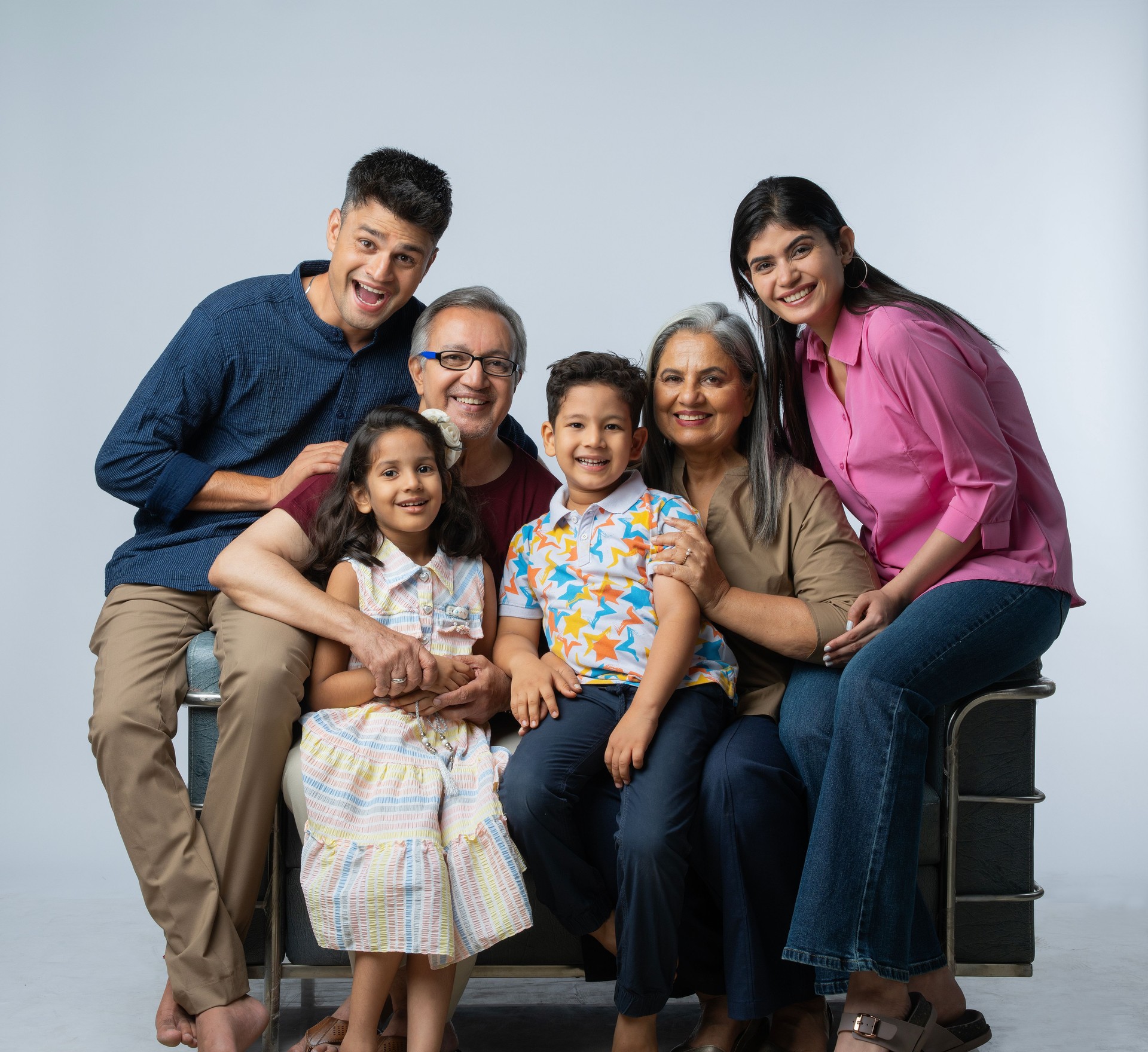 Three generation family sitting on sofa against white background